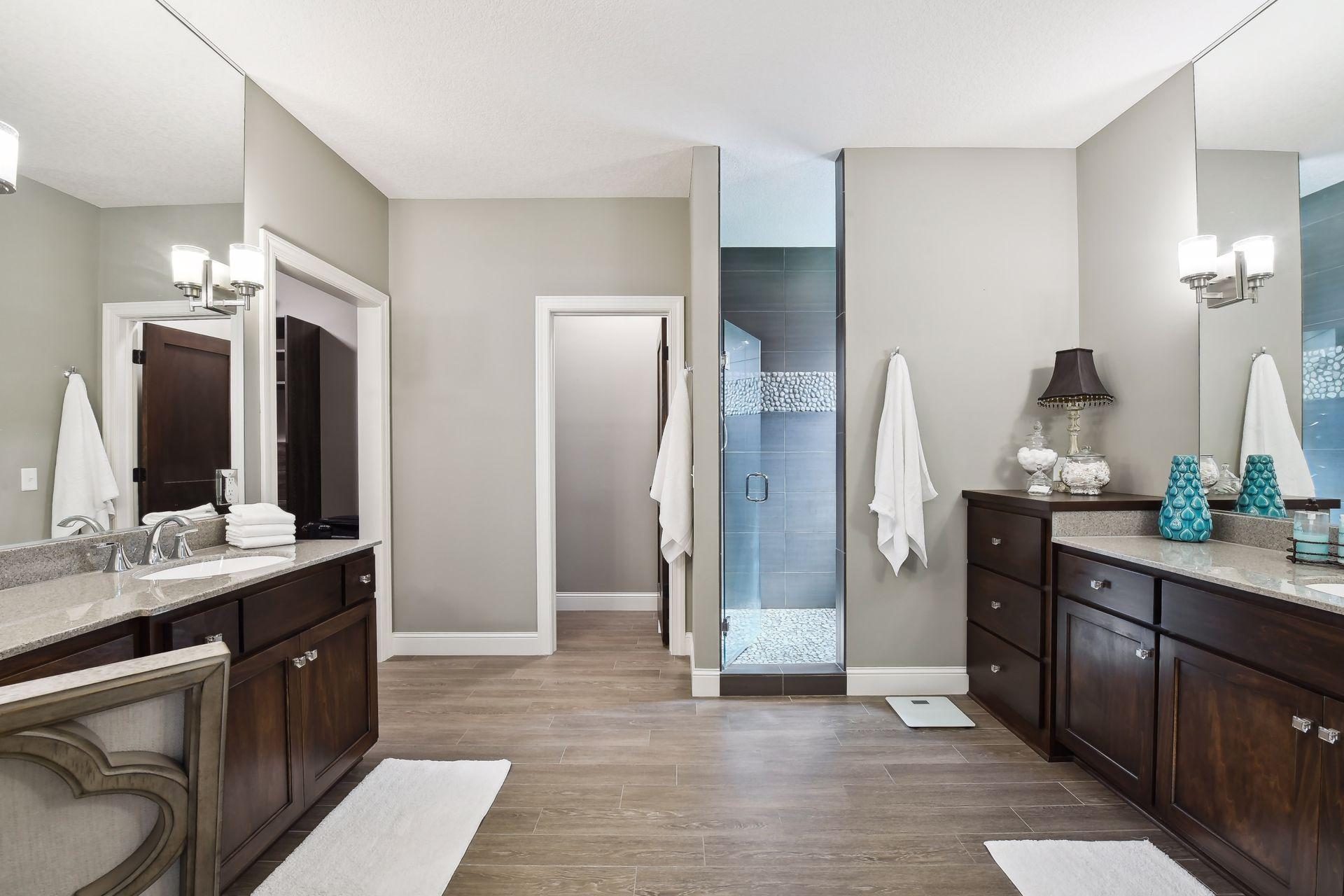 Spacious primary bath with dual vanities, private stool, walk in shower and large closet.