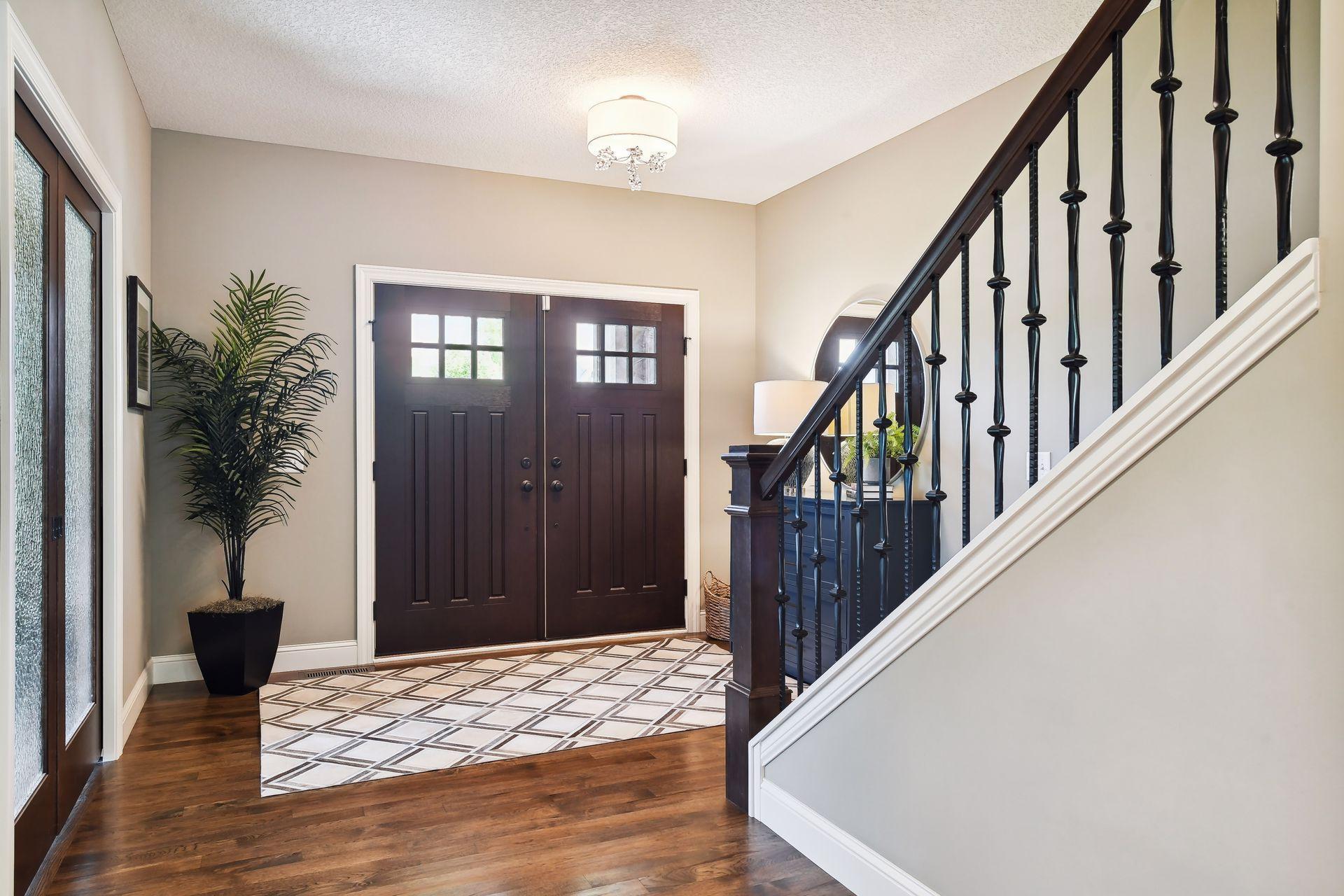Grand front entry with double doors. Leaded glass sliders open to ML office on the left with wide staircase to upper level loft and more bedrooms.