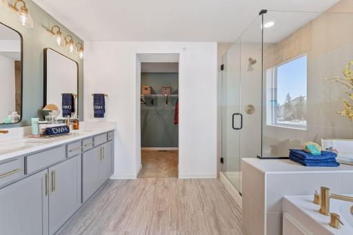 The owner's retreat offers convenience and luxury with an en suite bath and walk-in closet. A comfort height vanity, double sinks, quartz countertops and private water closet are provided because we know they are important to you. Model picture.