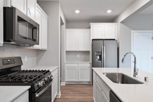 *Model Home - finishes may vary* This spacious kitchen features a pantry, Quartz kitchen counters, under mount sink, recessed lighting, LVP flooring, ss appliances and more!