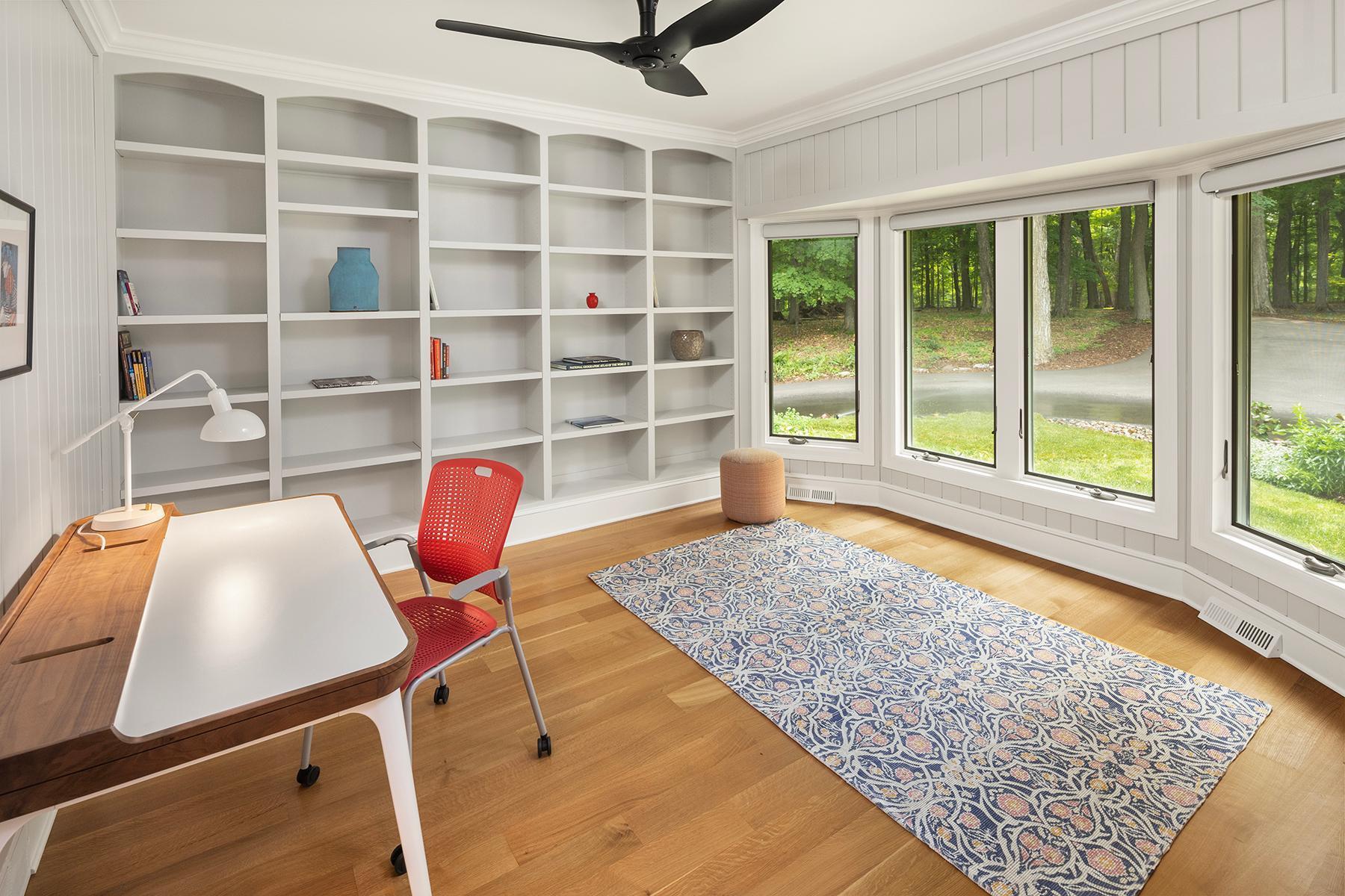 Den with Built-in bookcases and peaceful wooded views