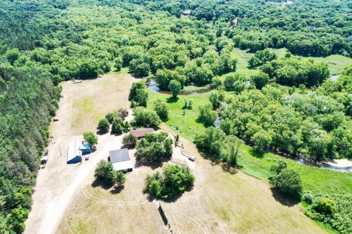 Drone view of property, meandering river with over 2500 ft of St Francis River front. Don't miss the hand crafted bridge on the river bend.