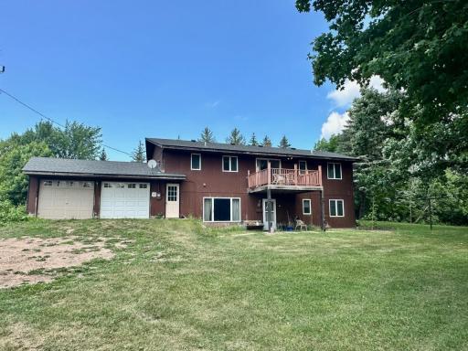 Back of home with walkout basement & deck o'looking trees and fields
