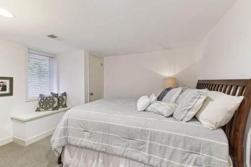 Fourth bedroom located on the lower level with a window bench seat and east facing window.