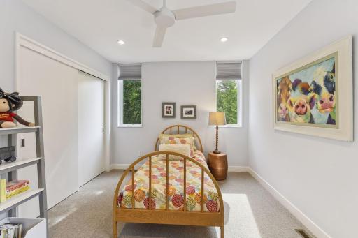 Third upper level bedroom with a large walk in closet, recessed lighting and ceiling fan.