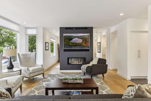 Linear two sided fireplace enjoyed from living and dining areas.