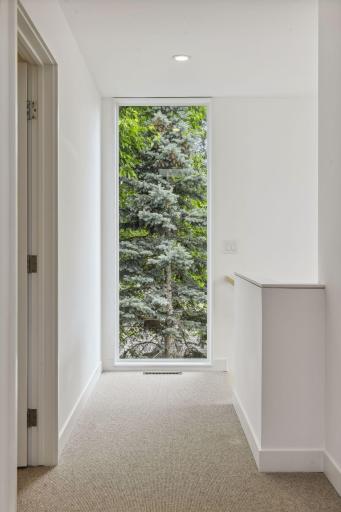 Floor to ceiling windows offer serene tree top views.