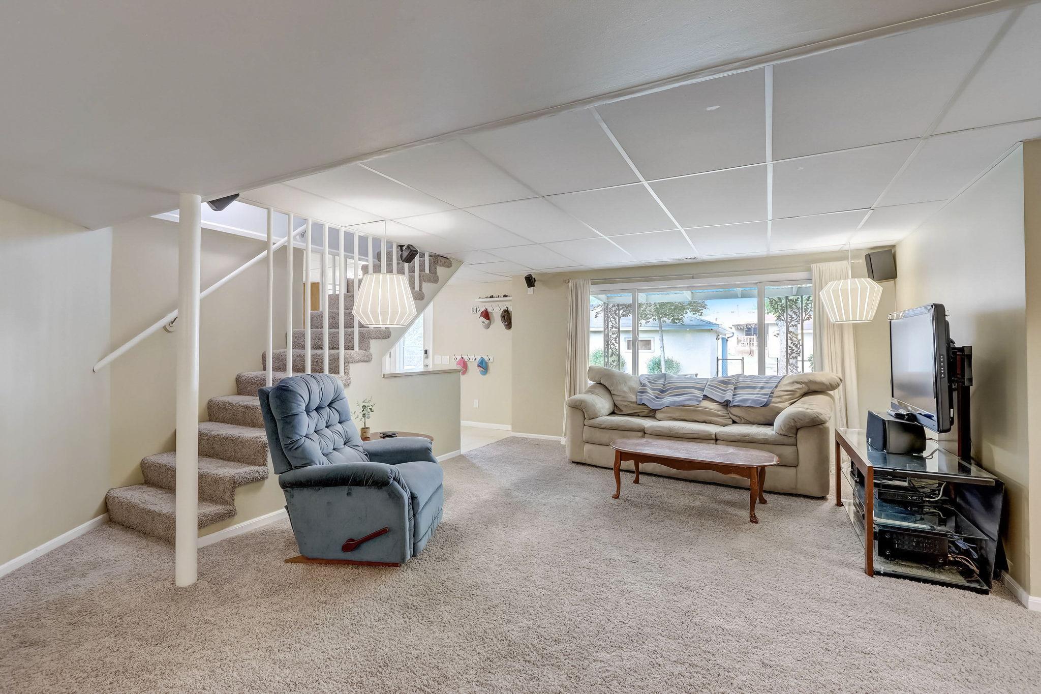 The walkout lower level features a fabulous family room with an oversized window providing an amazing private backyard view, stylish lighting throughout, and a cozy wood-burning fireplace.