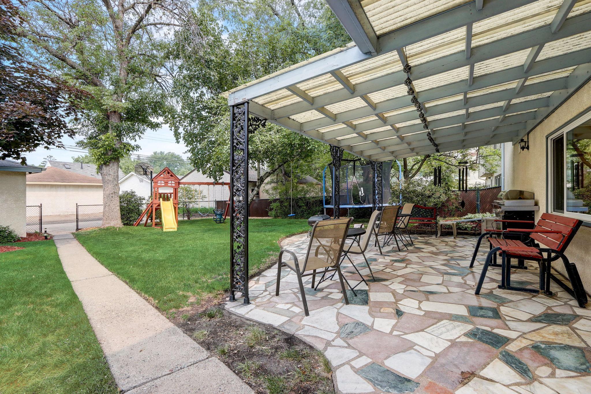 You will love the sprawling stone patio in the fully fenced backyard, with pergola above for shade, and mature trees surrounding for added privacy.