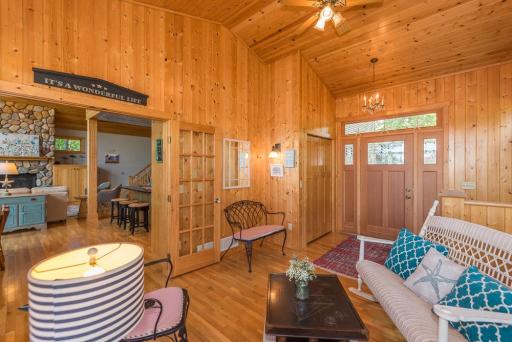 The entrance to the home has a beautiful panel wood door and it is surrounded in warm knotty pine.