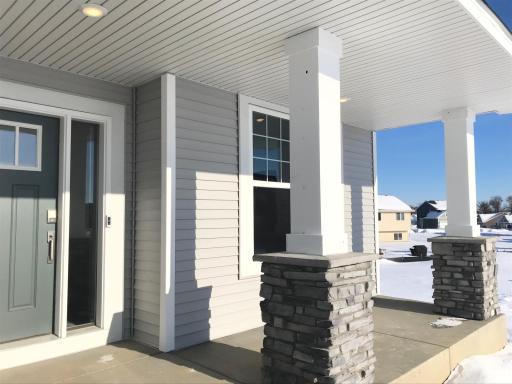 Stone pillars enhance the curb appeal of this cottage facade, notice the included keyless entry and ring doorbell. Finishes will vary.