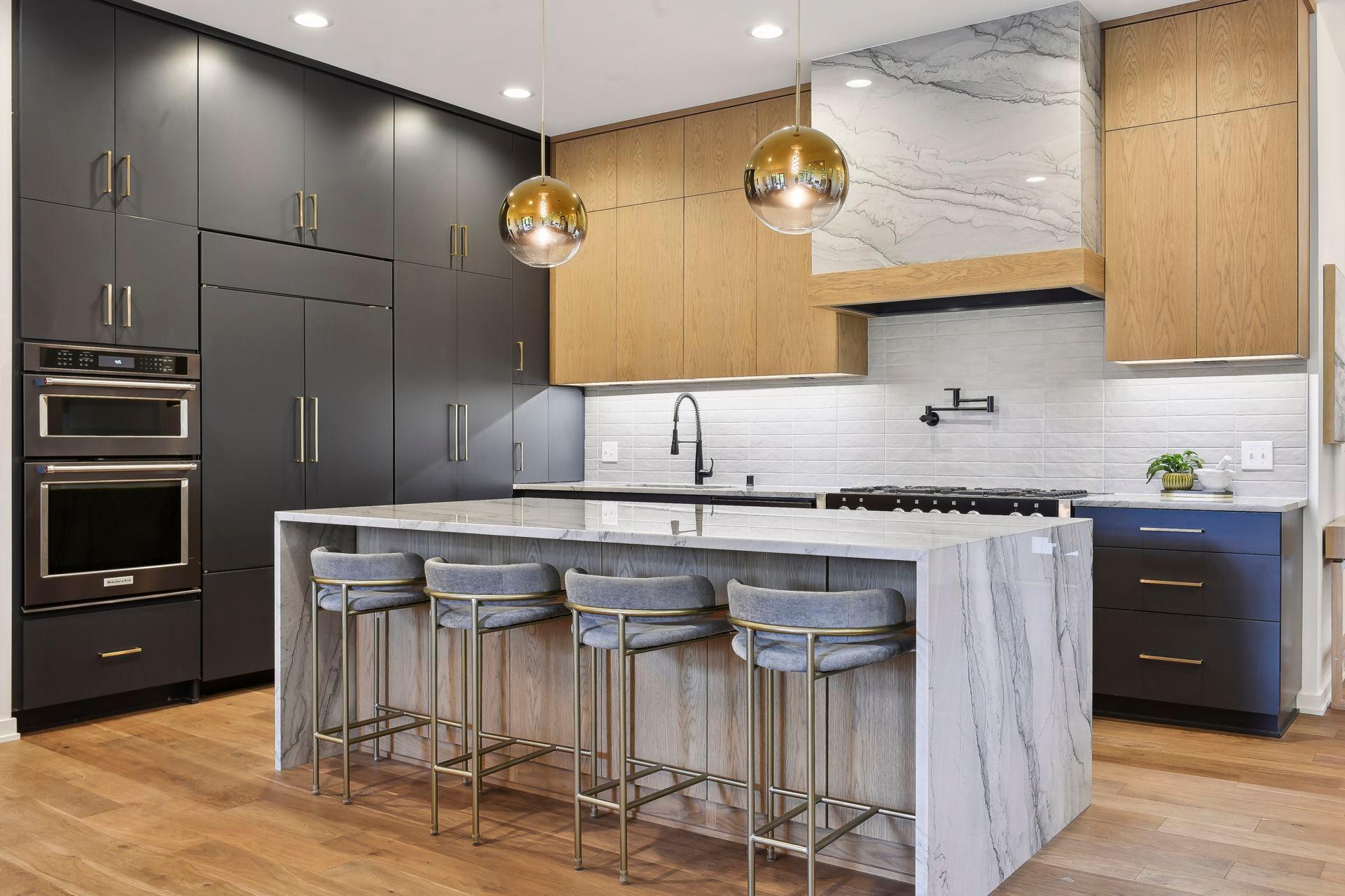 The home’s gourmet kitchen is a chef’s dream with four ovens, a show-stopping range hood, Quartzite countertops and an oversized island with waterfall stone.
