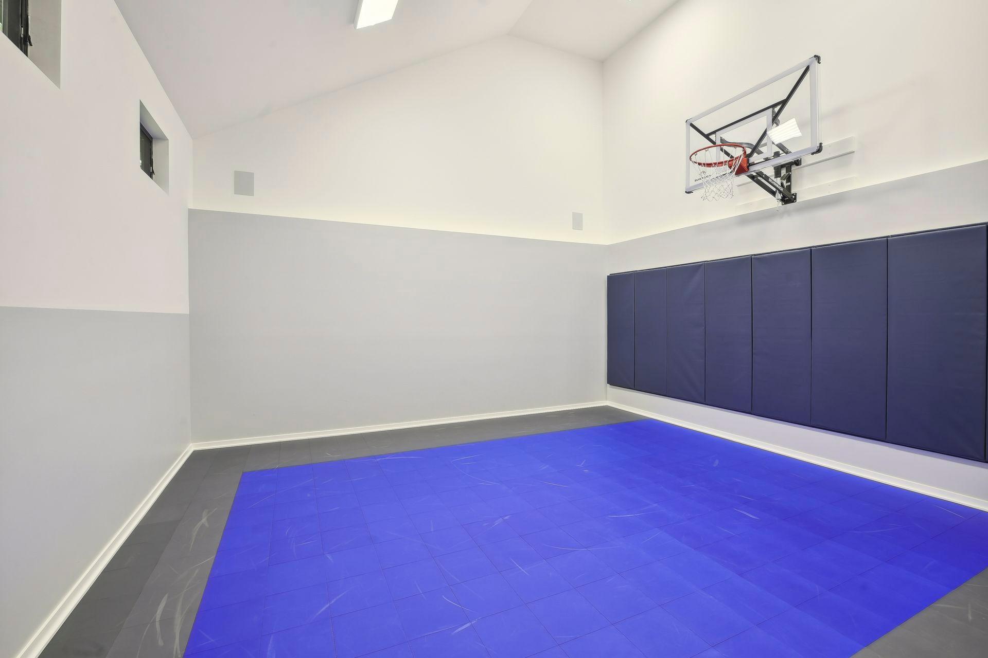 The lower level features a sport court with basketball hoop.