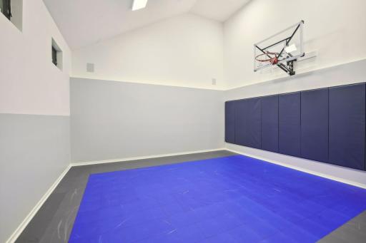 The lower level features a sport court with basketball hoop.