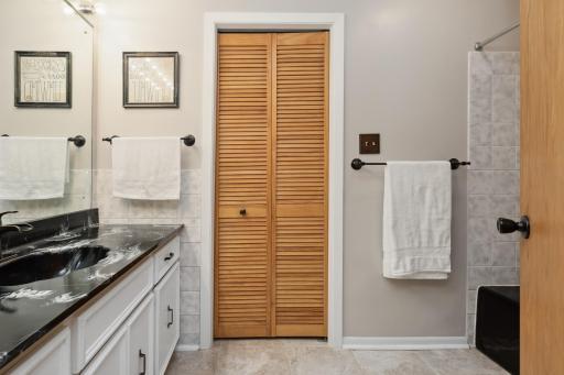 Main level - Full bath with extra deep tub and ceramic tile floors, oversized vanity and linen closet.