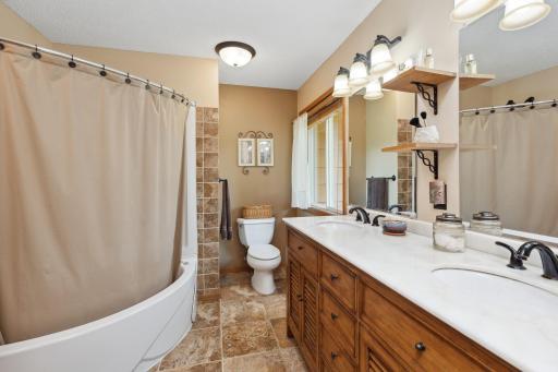 The bath was completely renovated adding an elevated double vanity, corner unit shower/jetted tub combination, ceramic tile flooring, new lighting, and storage.
