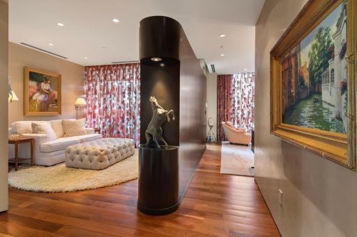 Custom curved wall with art nook divides the master suite from the sitting room, accented by lavish Brazilian walnut flooring.