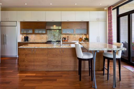 Sub Zero fridge and clean decorating in this well lit and thought out custom kitchen.