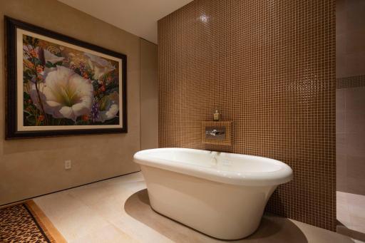 Exquisite mosaic tiled wall divides the shower from the vanity.