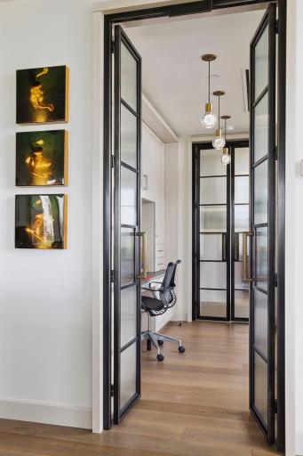 Through another set of doors you enter the office. This efficient space is flanked by a wall of glass onto a porch.