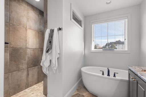 Primary bathroom features Italian tile floors and includes a soaking tub, tile walk-in shower and oversized vanity