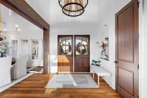 Soaring foyer features french doors, new chandelier and spacious coat closet
