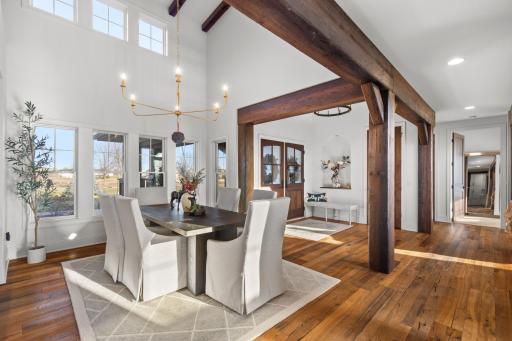 Open & bright dining room with vaulted ceilings, modern light fixture & views to the front yard