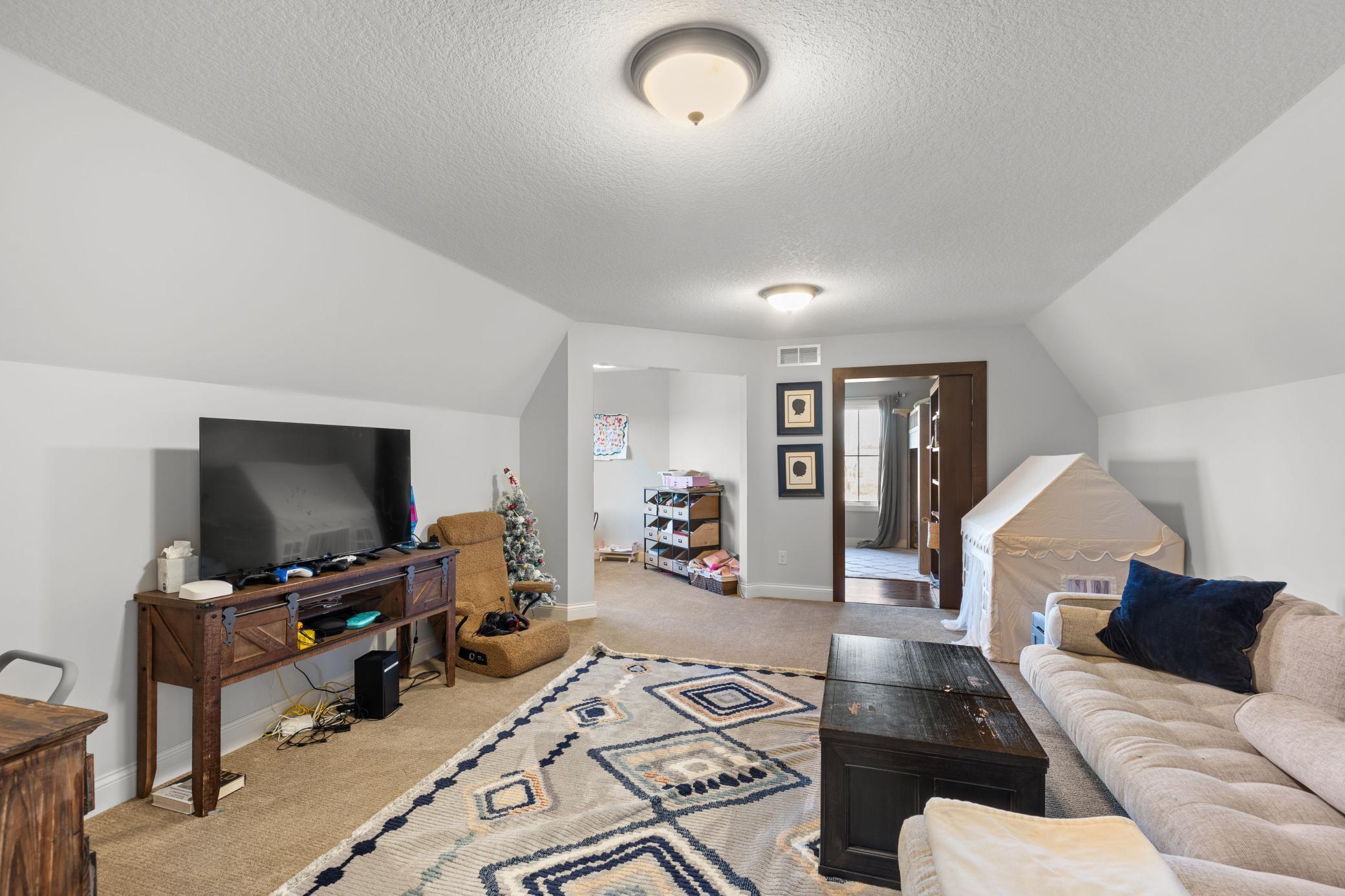 Upper level bonus living room offers a great space for a playroom, entertainment space, an extra family room and more! It leads to a craft/art room and a secret room behind the bookshelf