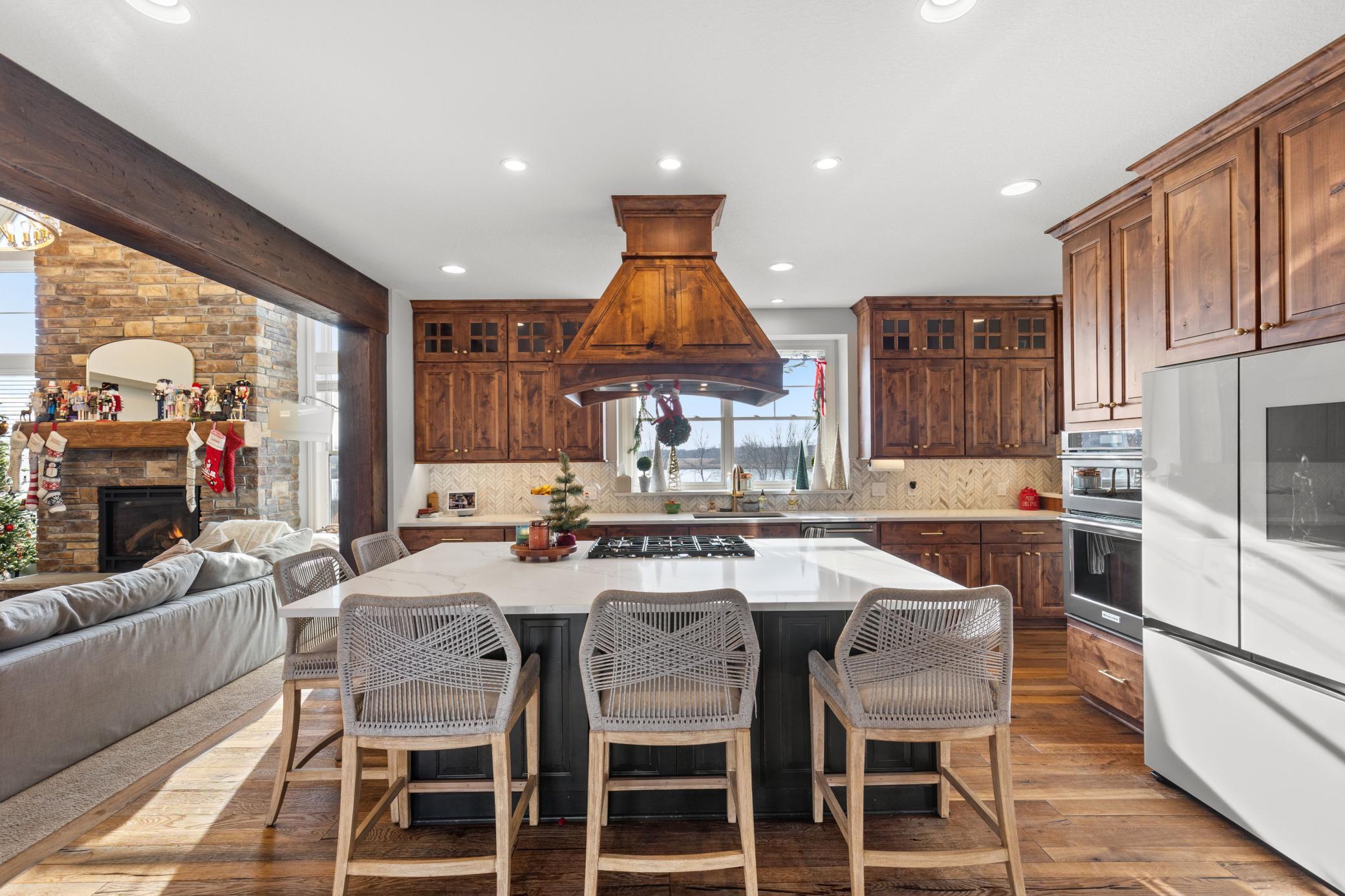 This gourmet kitchen features a large center island with plenty of space for seating & storage, new appliances, updated backsplash and beautiful alder cabinets