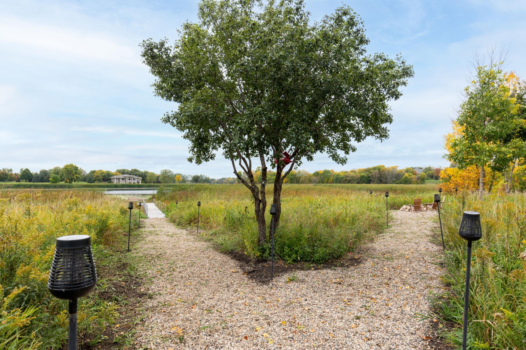 Two paths lead down to the firepit & dock on the pond