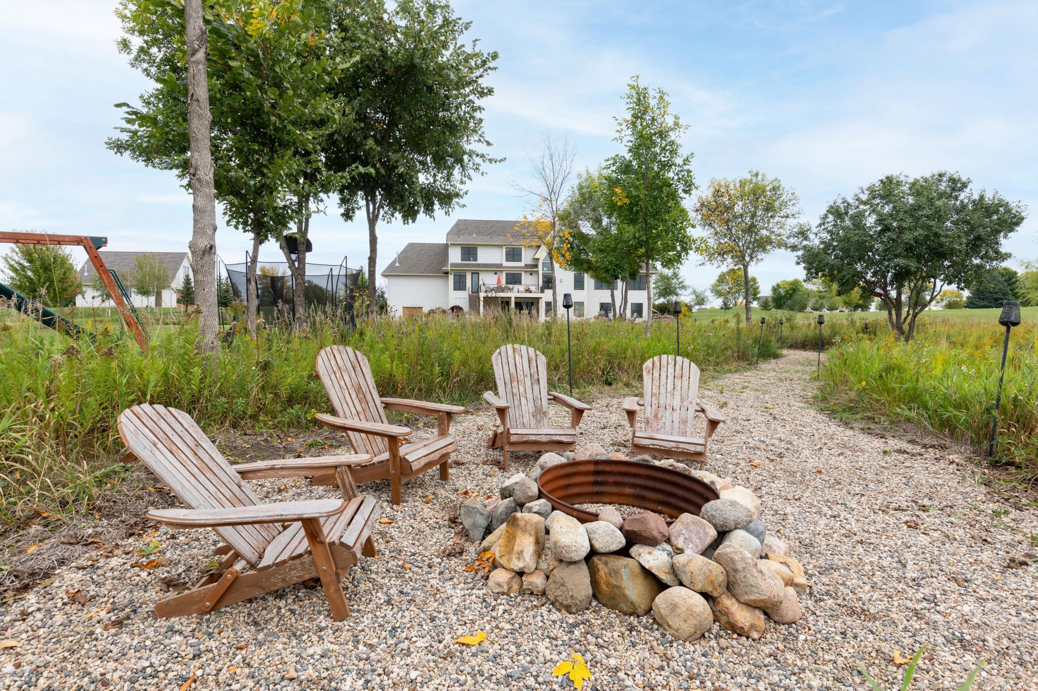 Private backyard firepit surrounded by nature with pond views