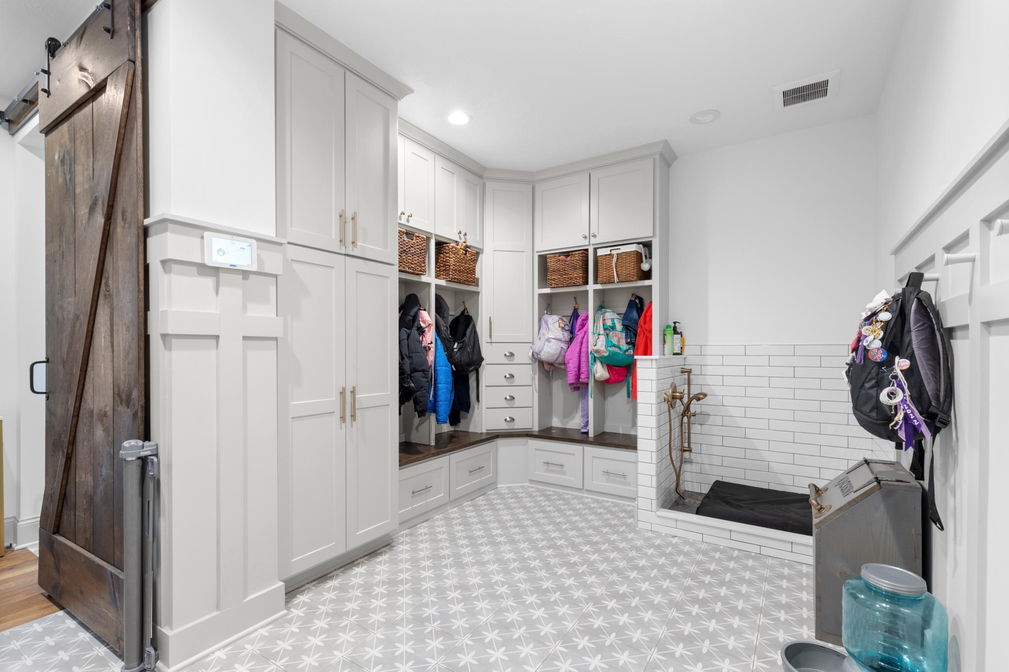 Mudroom includes plenty of storage in the built-ins and even a dog wash!