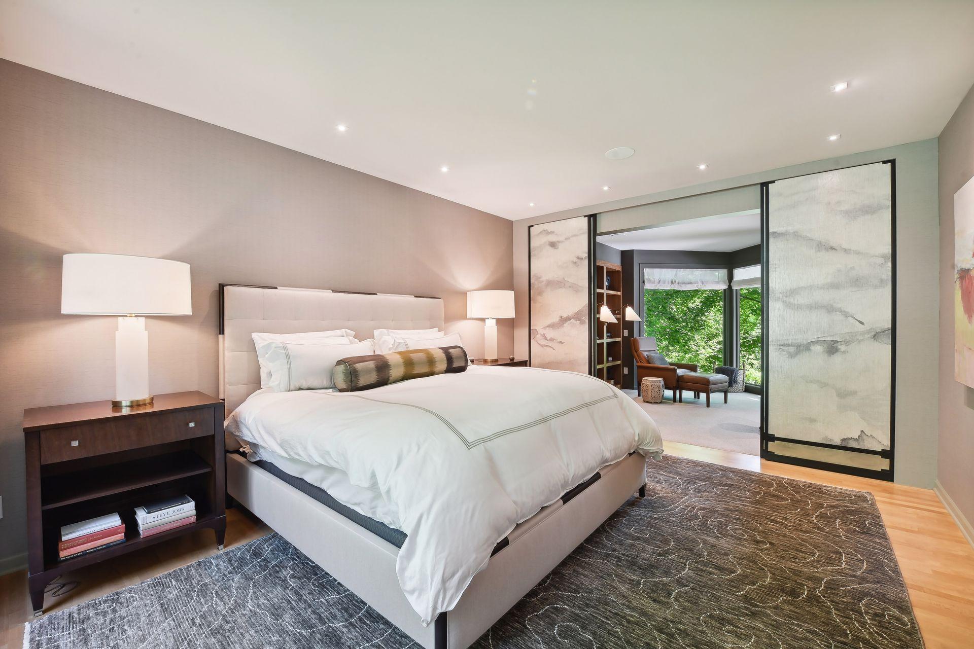 The main floor primary suite showcases an office with sliding doors, custom walk-in closet, and a luxurious wet room with freestanding soaking tub and waterfall feature.