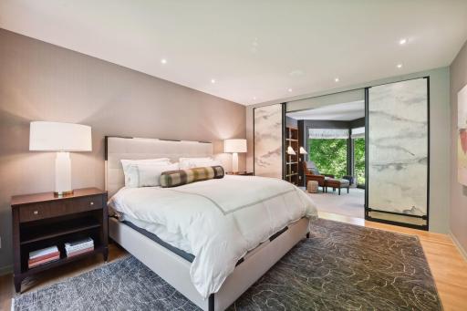 The main floor primary suite showcases an office with sliding doors, custom walk-in closet, and a luxurious wet room with freestanding soaking tub and waterfall feature.