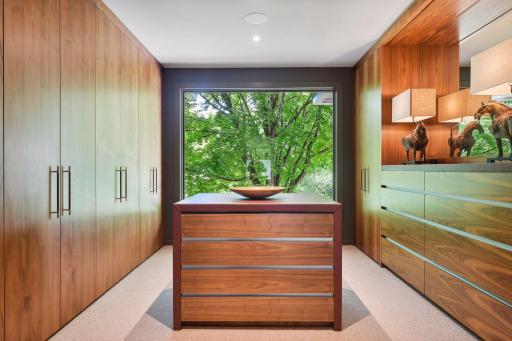 Incredible walk-in dressing room with custom wardrobes and drawers, complete with a view.