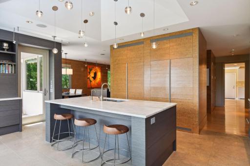 Custom kitchen is equipped with sparkling solid stone countertops, custom cabinetry and high end appliances.