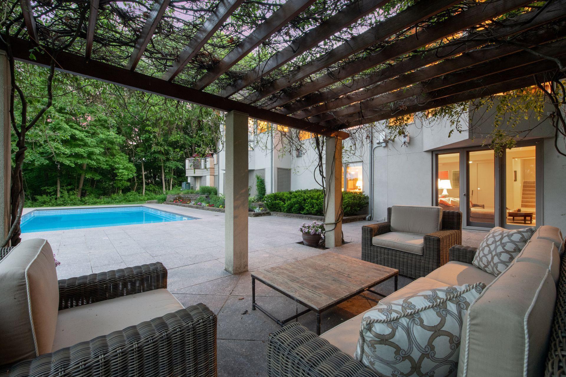 Connect with family and friends on the pool side patio under blooming wisteria.