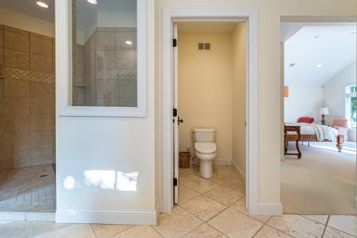 Primary bathroom features a large vanity with double sinks and storage, a jacuzzi tub, walk-in tile shower with double shower heads, recessed lighting, and a private toilet area.
