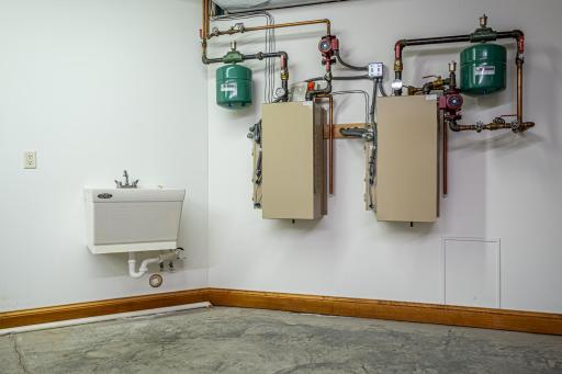 One of two mechanical rooms. Walk-out access to the garage. First mechanical room features a Kinetico water softener system, water filtration system, Marathon electric water heater, and Lennox forced air furnace with air-to-air exchanger.