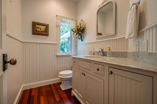 Hallway 1/2 bathroom features a marble countertop and Brazilian walnut flooring.