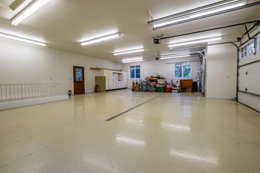 3-car garage features an epoxy floor, storage, and access to the basement.