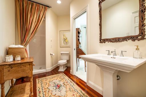 Main floor 3/4 bathroom off of the 2nd bedroom features a pedestal sink and walk-in tile shower.
