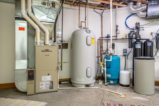 One of two mechanical rooms. Walk-out access to the garage. First mechanical room features a Kinetico water softener system, water filtration system, Marathon electric water heater, and Lennox forced air furnace with air-to-air exchanger.