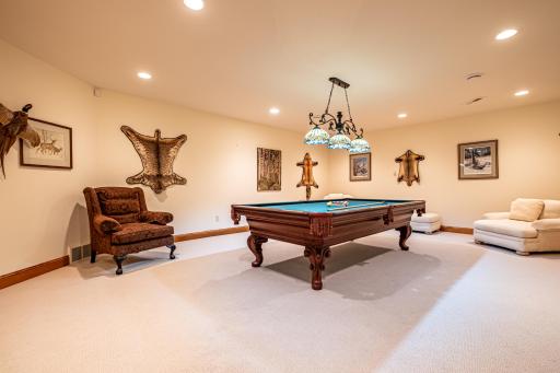 Lower level game room features a pool table and recessed lighting.