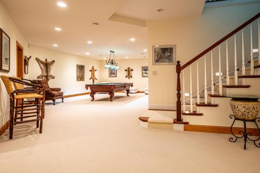Lower level game room features a pool table and recessed lighting.