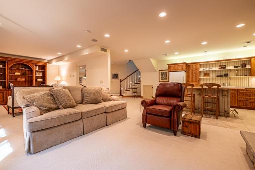 Lower level family room features a stone gas burning fireplace, recessed lighting, a study, and a full kitchen.