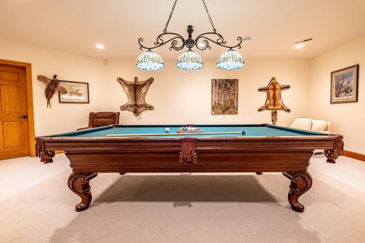 Lower level game room features a pool table and recessed lighting.