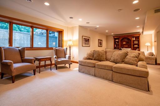 Lower level family room features a stone gas burning fireplace, recessed lighting, a study or sitting area, and a full kitchen.