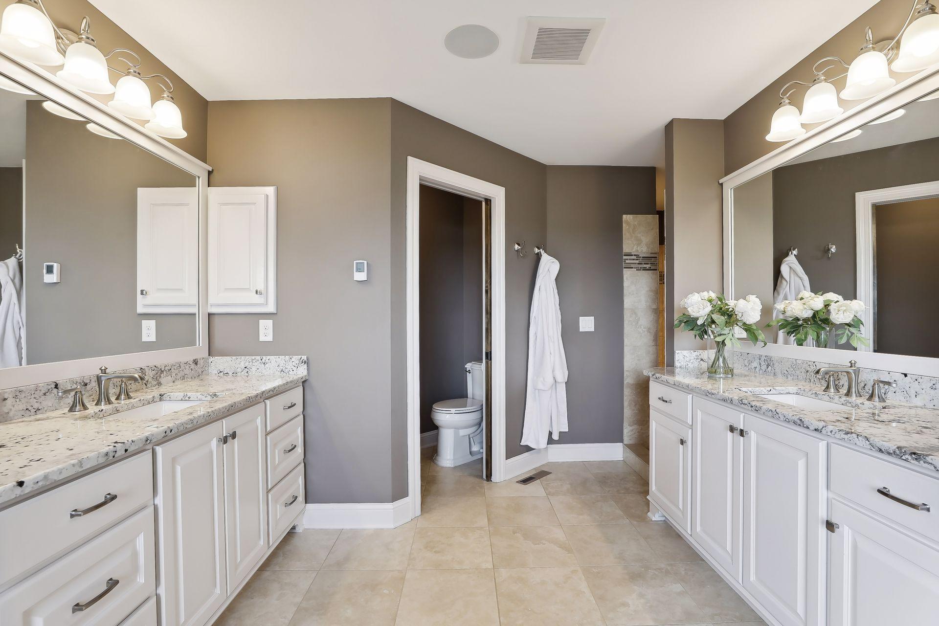 Heated marble floors and shower in private primary bathroom with separate vanities.
