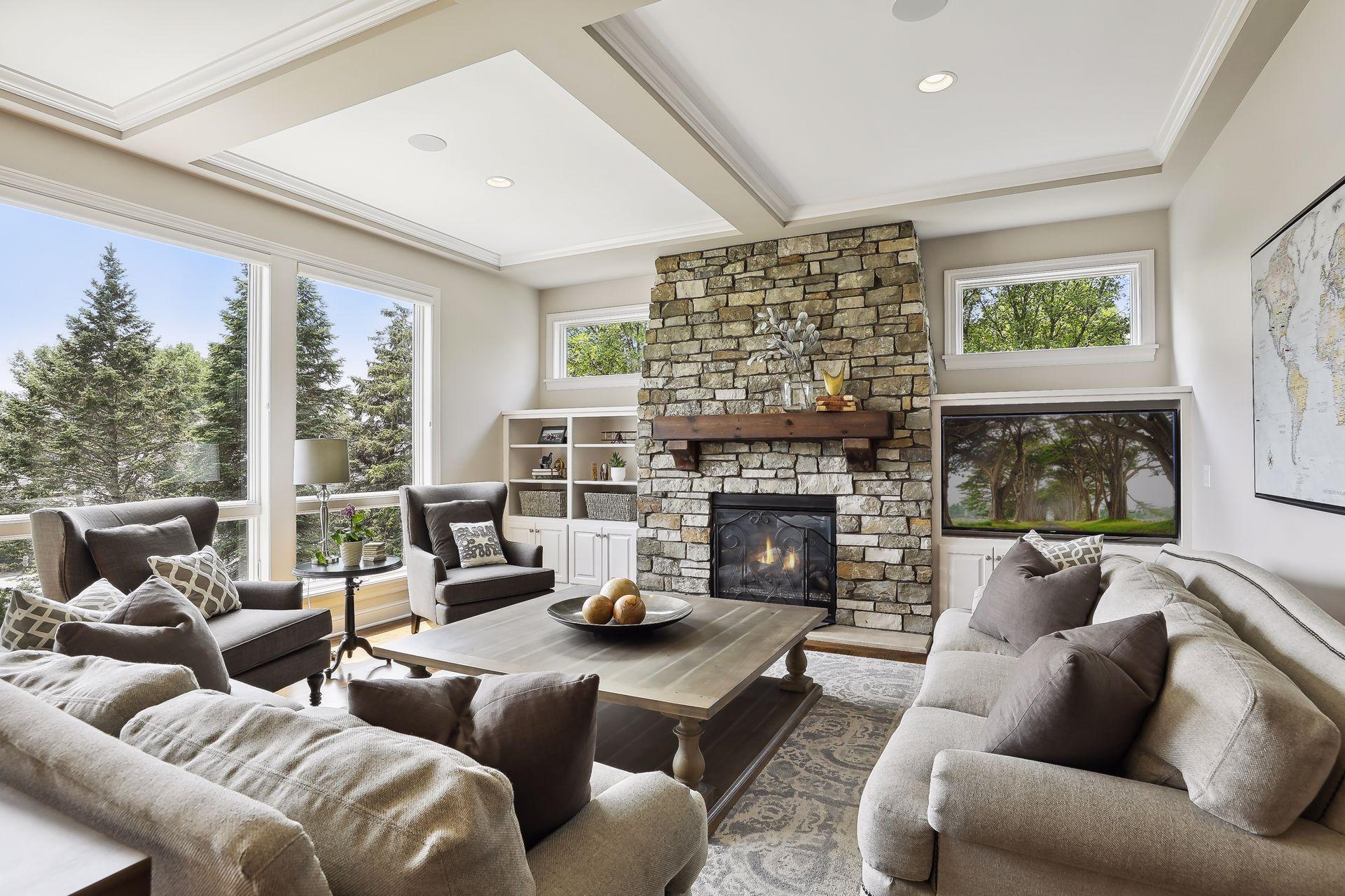 Great room with floor-to-ceiling natural stone fireplace flanked by custom cabinetry.